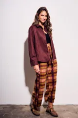 Camisa color marrón de gamuza sintética, de corte recto, con cuello clásico, cierre frontal con botones y mangas largas.