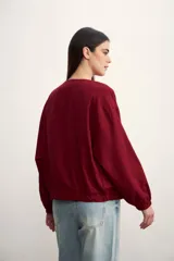 Chaqueta bomber negra con cierre frontal dorado y mangas largas con puños elásticos.