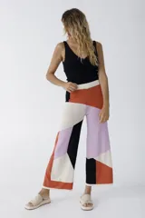 Pantalón palazzo de tejido de punto con diseño geométrico en bloques de color naranja, lila, beige y negro.