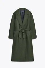 Abrigo largo color verde militar confeccionado en lana. Tiene cuello solapa, manga larga, bolsillos laterales y cinturón lazada en el mismo tejido. El forro interior es combinado a contraste.