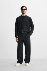 Sweater negro de punto con cuello redondo y manga larga. Presenta parches combinados a tono en hombros y codos.