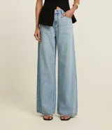 Pantalón de jean wide leg de tiro alto, color azul oscuro, con bolsillos delanteros y traseros, trabillas para cinturón y cierre frontal con cremallera y botón.