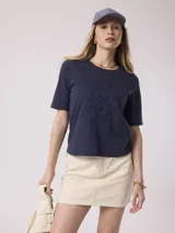 Remera azul marino de algodón con bordado floral en el frente.