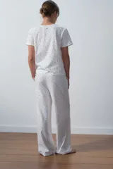 Conjunto de pijama blanco con estampado de lunares rojos, compuesto por una remera de mangas cortas y un pantalón palazzo.