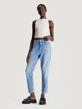 Jeans vintage de talle alto con pierna estrecha en el tobillo, confeccionados con denim de algodón elástico y fibras recicladas. Diseño de cinco bolsillos, bragueta con cremallera, lavado azul claro y bordado de Calvin Klein en la parte trasera de la cintura.