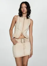 Minifalda beige de tiro bajo con cinturón y hebilla metálica, confeccionada en tejido denim de algodón.