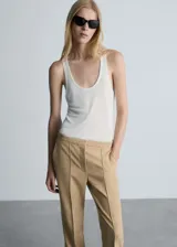 Pantalón de vestir color beige, de tiro medio y corte acampanado.