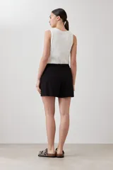 Short negro de corte recto con cintura elastizada y cordón ajustable. Presenta bolsillos laterales y detalle de costuras verticales en el frente.