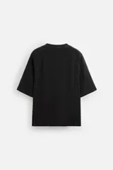 Camiseta negra de corte relaxed fit, cuello redondo y mangas cortas. Tejido de punto con textura acanalada y efecto lavado.