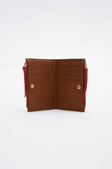 Billetera de cuero color marrón con doble monedero con cierre y botón a presión, reparticiones internas y bolsillos forrados con algodón.