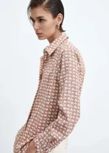 Camisa de manga larga con cuello camisero y cierre de botones frontal. Estampado geométrico en tonos terracota y blanco.