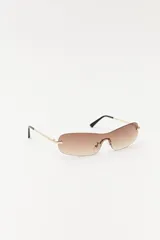 Lentes de sol con lentes marrones degradé sin marco y patillas doradas.