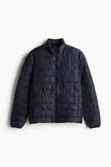 Campera puffer azul marino, liviana, en tejido guateado con cuello elevado y cierre con protección para el mentón. Bolsillos con cierre oculto en las costuras laterales. Forrada y de corte ajustado.