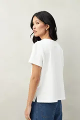 Remera blanca de algodón con cuello redondo y mangas cortas.