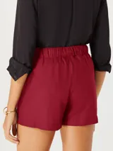 Short de tela color rojo con cintura elastizada, lazo ajustable y bolsillos laterales.