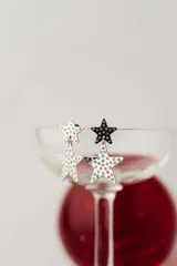 Aros colgantes de acero quirúrgico con baño de oro, con diseño de dos estrellas decoradas con circonias.