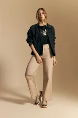 Remera de manga corta color negro con cuello redondo y un aplique bordado de flores y hojas en color beige claro en el centro del pecho.