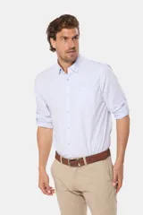Camisa celeste a rayas verticales, de manga larga con opción de arremangar, corte slim fit y bolsillo en el pecho. Confeccionada en algodón.