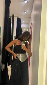 Vestido midi negro con estampado de lunares blancos, breteles finos y falda con volados y transparencias.