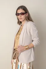 Blazer beige de algodón con solapa entera, bolsillos delanteros y frunce en las mangas 3/4.