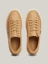 Zapatillas Tommy Hilfiger color beige de lino orgánico con monograma TH dorado en el lateral.