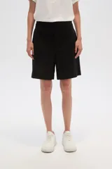 Short de lino color blanco, de calce alto y con bolsillos laterales.