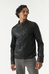 Campera de cuero sintético negra con cuello mao, cierre frontal con cremallera, bolsillos laterales con cremallera y detalle de costuras en los hombros.