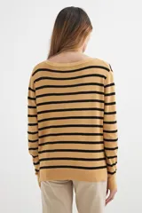 Sweater color beige con rayas horizontales negras y escote en V.