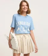Remera celeste de algodón con estampado blanco que incluye la palabra "Cambridge", un ancla y la frase "Massachusetts Crew".