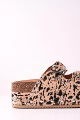 Sandalias con plataforma de corcho, con estampado animal print en tonos beige y negro, y hebillas metálicas plateadas.