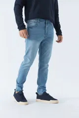 Pantalón de jean gris oscuro, corte carrot, tiro medio, con logo bordado y presillas para cinturón.
