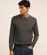 Suéter gris de punto para hombre, con cuello redondo, sisas ligeramente desplazadas y bajo y puños acanalados.