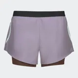 Short deportivo 2 en 1 color lila con cintura elástica negra, calza interior marrón y logo reflectivo.