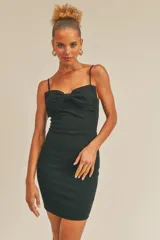 Vestido corto negro ajustado al cuerpo, con tirantes finos regulables y detalle de moño en el busto.