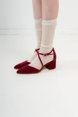 Zapato de tacón bajo color negro, con punta fina y tiras cruzadas sobre el empeine.