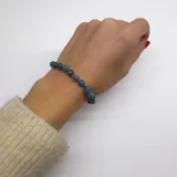 Pulsera elástica con cuentas de apatita azul verdoso de 6mm, separadores de hilo turquesa y terminaciones de acero hipoalergénico con baño dorado.