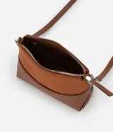 Cartera de hombro pequeña marca Satinato, color marrón, con diseño dividido en dos texturas: parte superior aterciopelada (suede sintético) y parte inferior lisa de cuero sintético. Cuenta con bolsillo delantero amplio, asa ajustable y desmontable con herrajes metálicos plateados, y cierre superior con cremallera y tirador alargado.