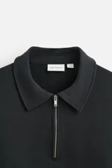 Sudadera negra de algodón con cuello polo y cierre de cremallera.