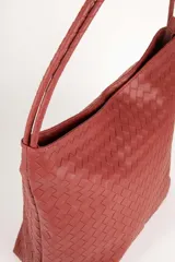 Cartera tipo bolso en símil cuero negro trenzado, con asas fijas centrales y gran compartimento interior.