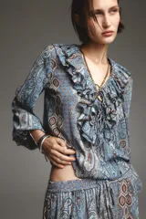 Camisa de manga larga con estampado cachemir en tonos celeste, azul y marrón. Presenta escote en V con volantes y lazos.
