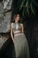 Top dorado de tejido de punto con lurex, corte halter, espalda descubierta y abertura en el pecho.