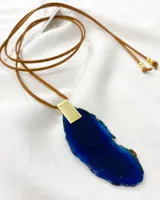 Collar con colgante de piedra azul en forma orgánica, con cadena de cuero color marrón.