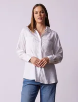 Camisa blanca de lyocell, marca Dash. Tiene cuello con solapa, abertura central con botones, mangas largas regulables con presilla y botón, y dos bolsillos delanteros aplicados.