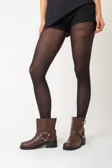 Botas cortas de ecocuero color chocolate, con base de 1,5 cm, taco de 2,5 cm y caña de 21 cm de alto. Presentan dos correas con hebillas y un arnés con argolla metálica.