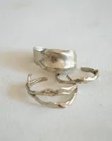 Brazalete rígido de bronce y alpaca maciza, con diseño orgánico irregular.