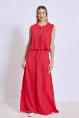 Pantalón ancho de tiro alto color rojo, con pliegues verticales en la parte superior y caída fluida.