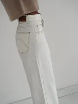 Pantalón vaquero celeste de tiro alto, corte recto con tajo lateral y terminación en cuero.