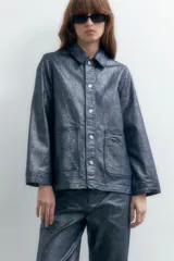 Sobrecamisa de denim metalizado color azul con cuello clásico, cierre frontal con botones, bolsillos de parche en el pecho y mangas largas.