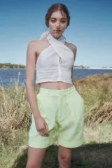 Bermuda de broderie color verde lima, de talle alto, con pliegues debajo de la cintura, piernas anchas con tablas y botamanga.