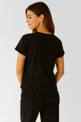 Remera verde militar de algodón con estampado de flores y texto en color crema.